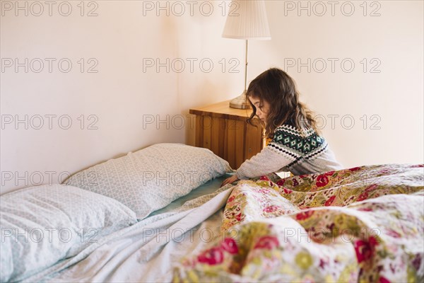 Girl arranging bedsheet bedroom