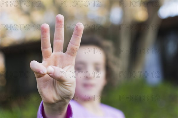 Girl showing three finger salute hand gesture