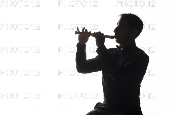 Silhouette man playing flute