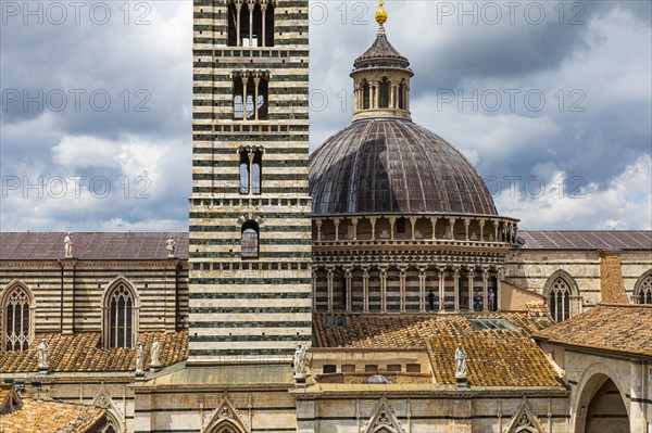 Dark clouds over the Siena Cathedral with its black and white striped marble facade