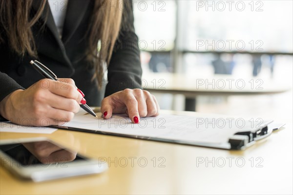 Brunette businesswoman writing document