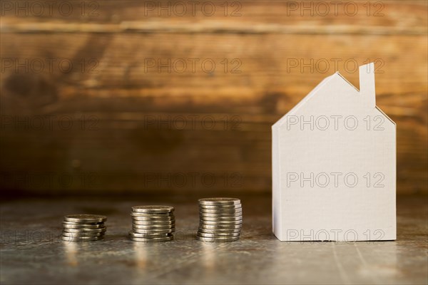 Increasing stack coins near paper house surface