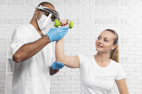 Male physiotherapist checking woman s strength