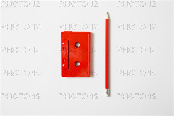 Red cassette tape pencil white background