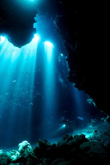 Diver swimming in cave