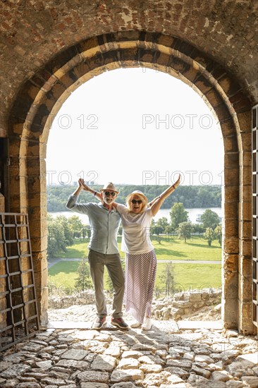 Couple raising their hands air front door