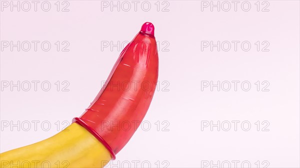 Banana with red condom copy space