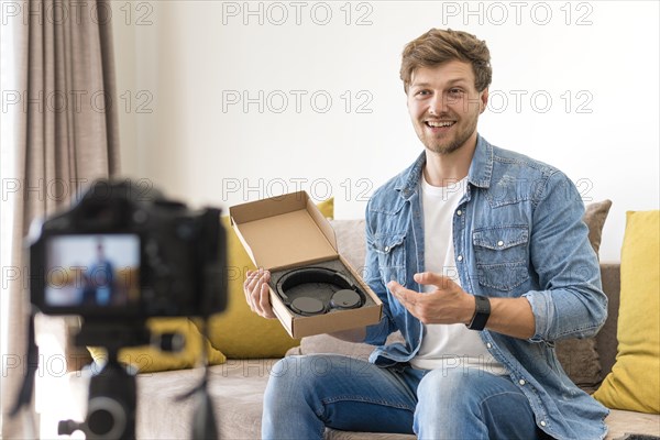 Handsome male recording unboxing video home