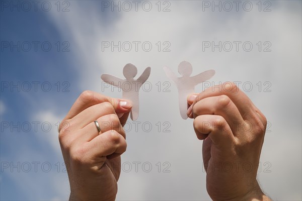 Paper men against sky