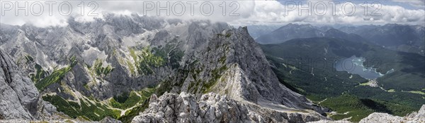 View from the summit of the Waxenstein over rocky and narrow ridge of the Waxenstein ridge to Eibsee lake and Hoellental with Jubilaeumsgrat