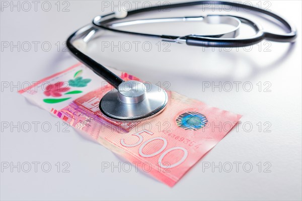 Close up of stethoscope on 500 cordobas bill on isolated background. Nicaraguan medical healthcare cost concept