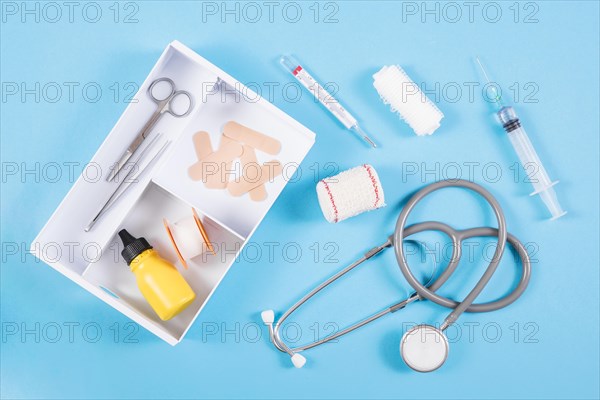 Open first aid kit with medical equipments blue background