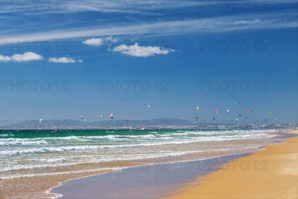 Kiteboarding kitesurfing kiteboarder kitesurfer kites on the Atlantic ocean beach at Fonte da Telha beach