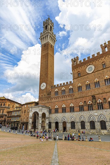 Atmospheric clouds at the Piazza del Campo with its bell tower Torre del Mangia and the town hall Palazzo Pubblico