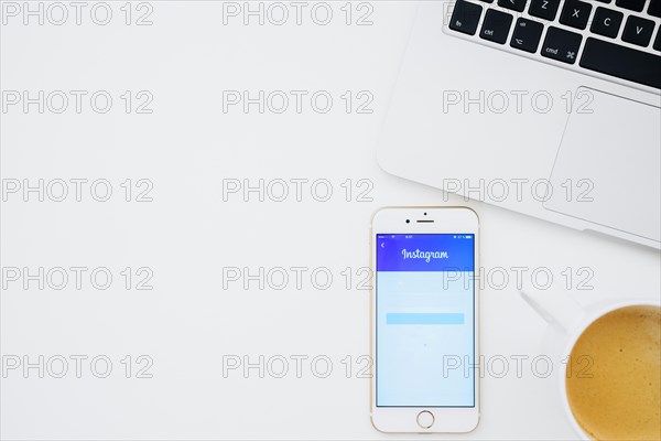 Instagram app phone with coffee laptop