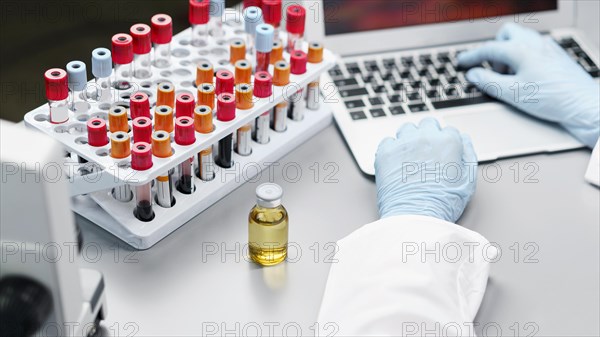 Female researcher laboratory with vaccine bottle test tubes