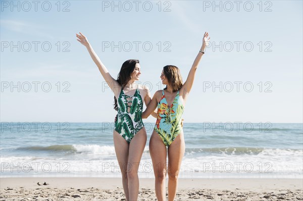 Girls raising arms beach