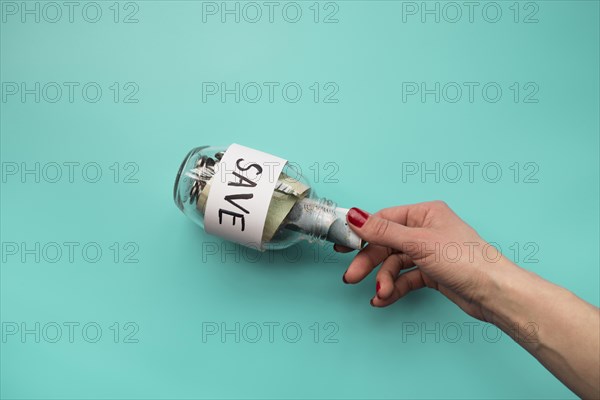 Hand putting money into jar