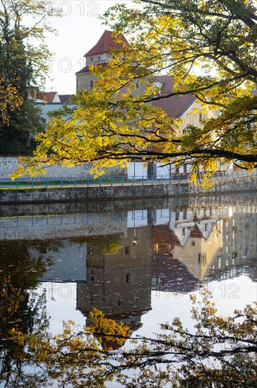 Autumnal coloured trees in the park Hajecek with the river Maltsch and the city wall of the historical old town of Ceske Budejovice