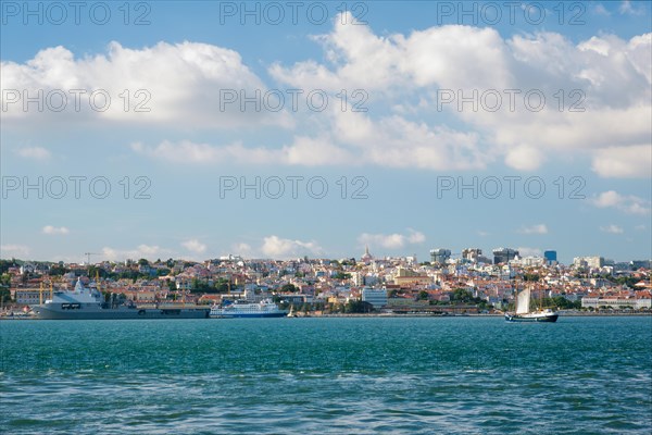 View of Tagus river with tourist boat and moored NATO warships in Lisbon