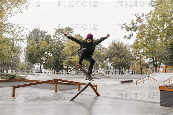 Man outside with skateboard park