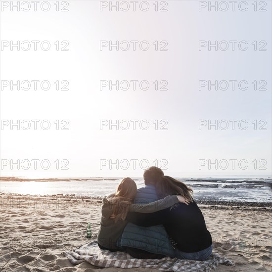 People hugging looking sea