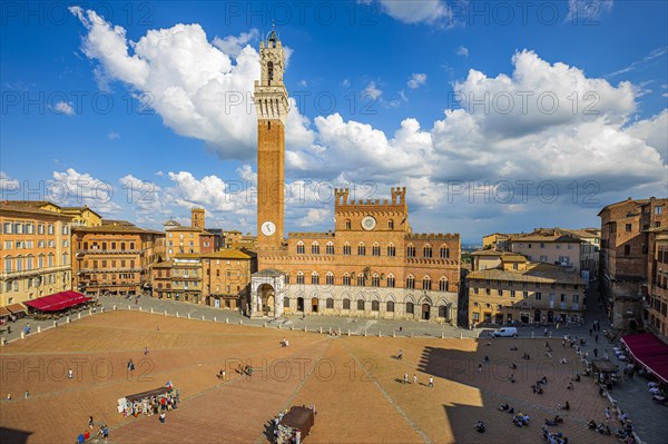 Spring clouds over the Piazza del Campo with the bell tower Torre del Mangia and the town hall Palazzo Pubblico