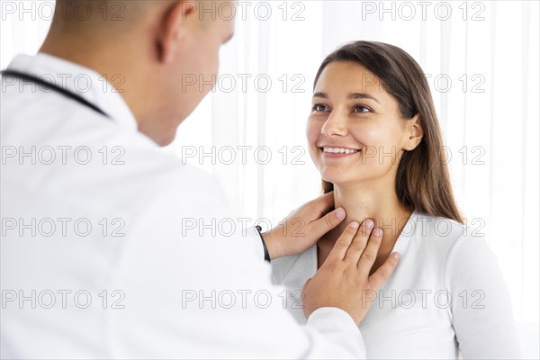 Back view doctor examining woman neck