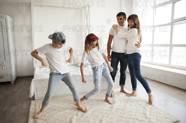 Children dancing front their loving parent home