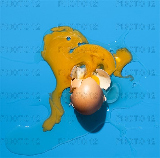 Top view broken egg blue background