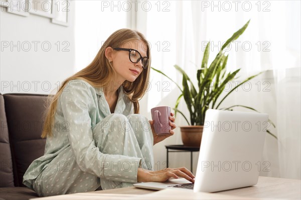 Side view woman working laptop from home