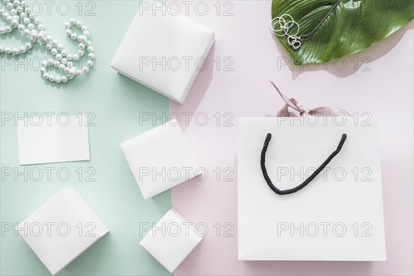 Different white boxes with shopping bag pink green background