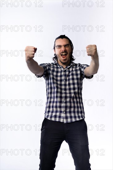 Happy bearded man raising his hands showing victory gesture. Handsome guy just won a game. Isolated on white background