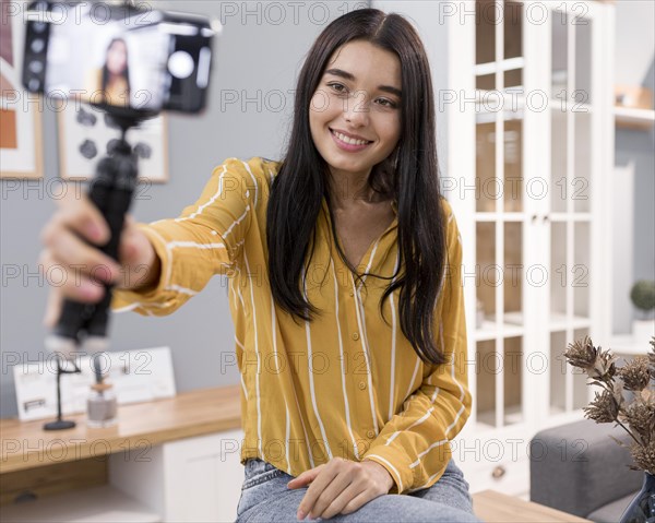 Female vlogger home with smartphone