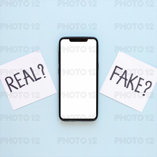 Sticy notes with fake news beside phone