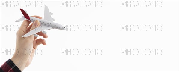 Front view hand holding airplane figurine with copy space