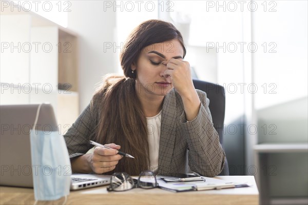 Tired businesswoman working desk with laptop