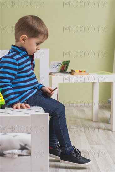 Pensive boy sitting bed