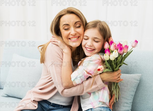 Mom daughter with satisfied face hugging each other