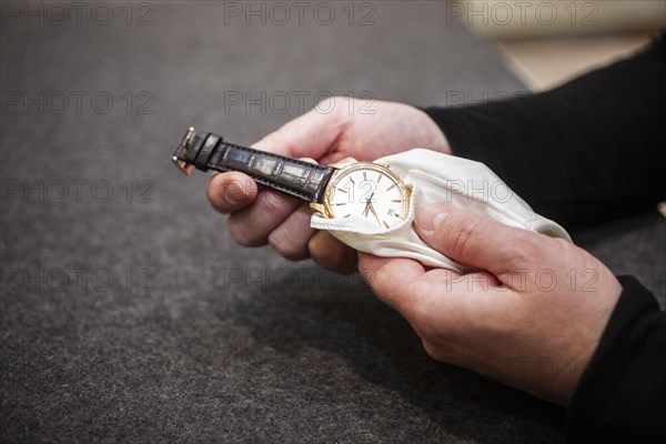 A man cleans a luxurious wristwatch