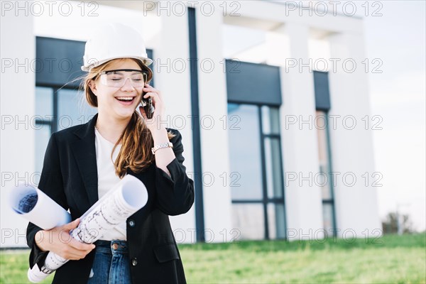 Cheerful architect woman talking phone