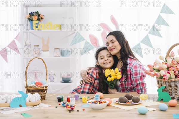 Pleasing mother embracing her daughter celebrating easter day