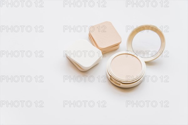 Close up cosmetic realistic plastic compact powder with sponges white backdrop
