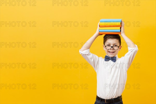 Copy space boy holding stack books