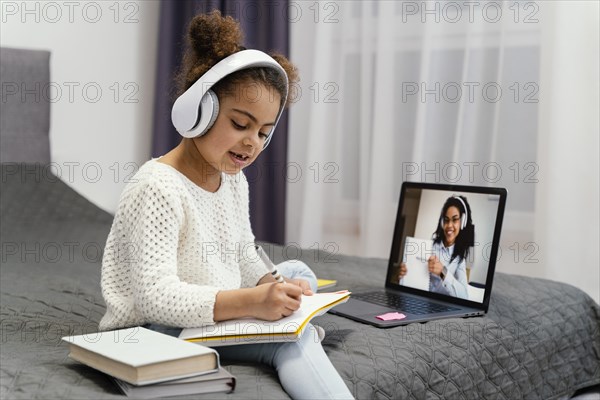 Little girl using laptop online school