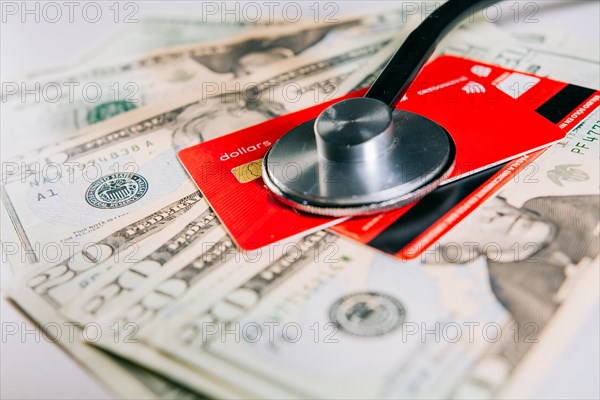 Concept of online medical payments with credit card. Stethoscope with bank notes and credit card