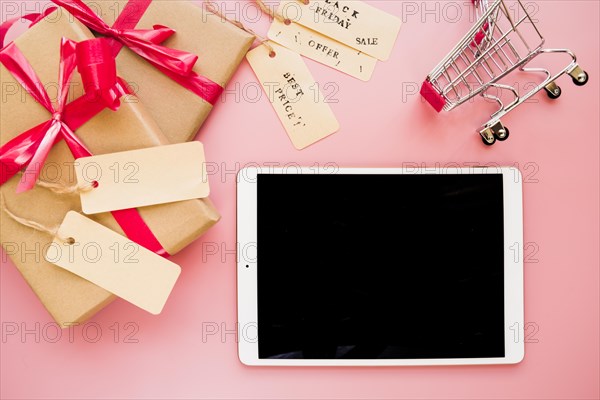 Laptop near shopping trolley present boxes