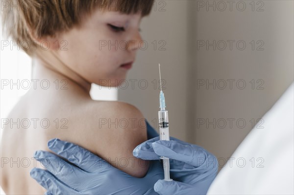 Doctor with gloves performing vaccine little child