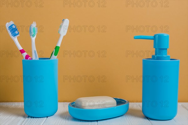 Toothbrushes soap soap dispenser bottle white desk against wall