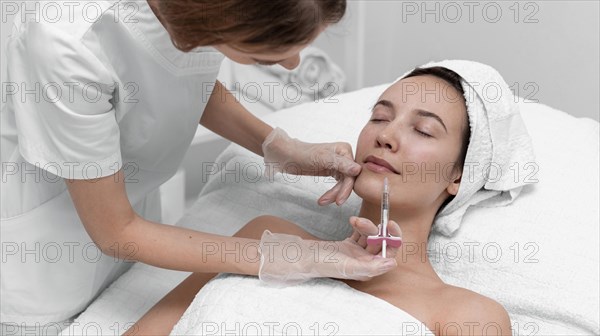 Beautician doing injection filler female client